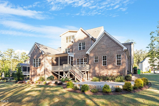 rear view of house with a yard and a sunroom