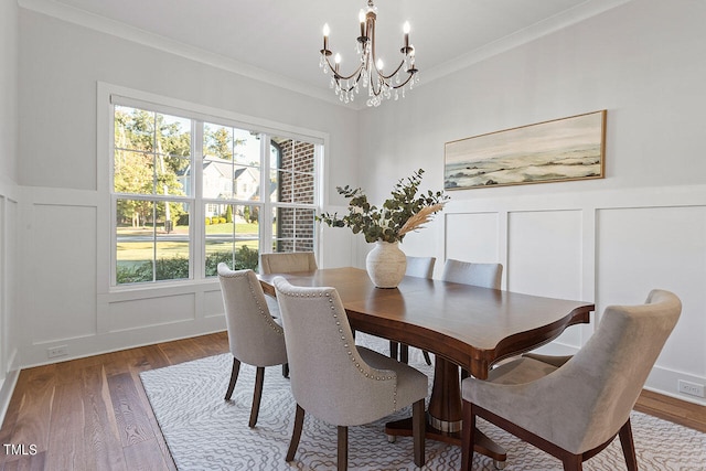 dining space featuring crown molding, a chandelier, and hardwood / wood-style floors