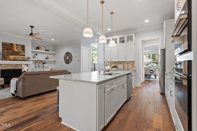 kitchen featuring a center island with sink, sink, white cabinets, and plenty of natural light