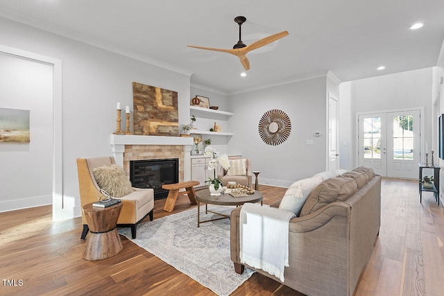 living room with crown molding, french doors, light wood-type flooring, and ceiling fan