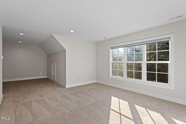 additional living space featuring lofted ceiling and light colored carpet