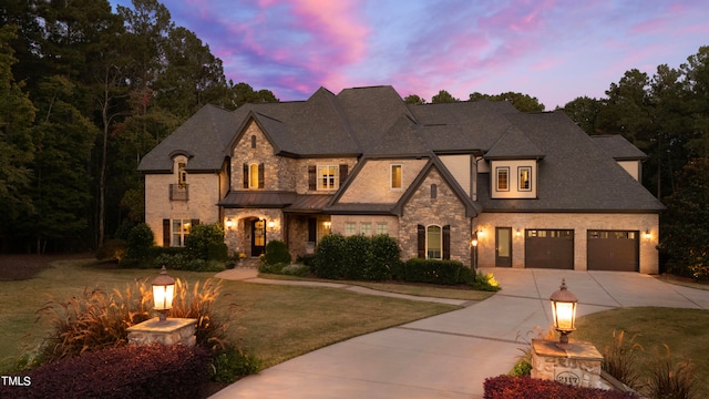 view of front of house with a garage and a yard