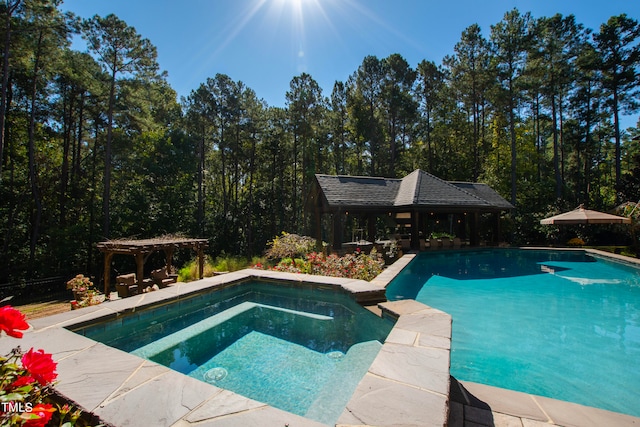 view of swimming pool featuring a gazebo and an in ground hot tub