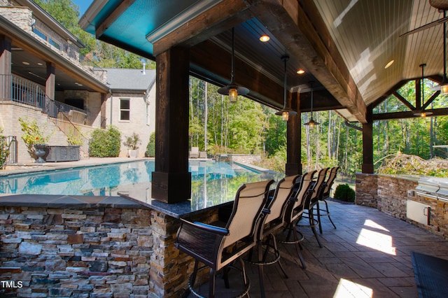 view of pool with exterior bar and a patio area