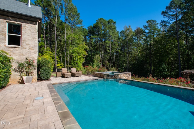 view of pool with an in ground hot tub and a patio