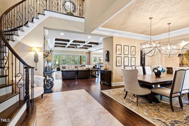 dining space with hardwood / wood-style floors, a notable chandelier, crown molding, coffered ceiling, and beam ceiling