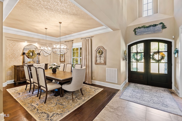 dining area featuring crown molding, a chandelier, french doors, and dark hardwood / wood-style floors