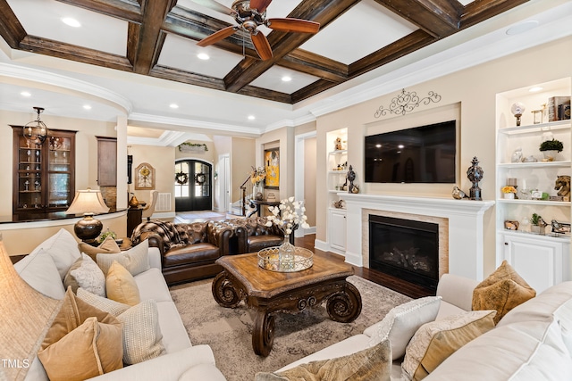 living room featuring built in features, ornamental molding, beam ceiling, and coffered ceiling