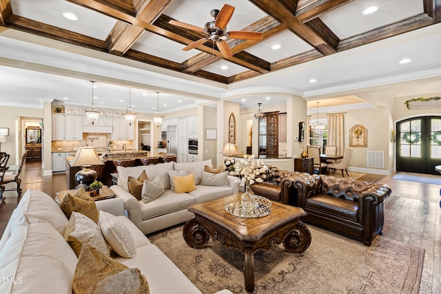 living room featuring beamed ceiling, ornamental molding, french doors, coffered ceiling, and hardwood / wood-style flooring