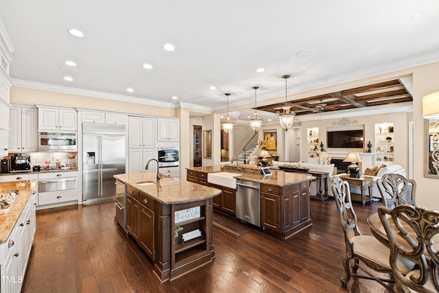 kitchen featuring a center island with sink, dark brown cabinetry, appliances with stainless steel finishes, and dark hardwood / wood-style floors