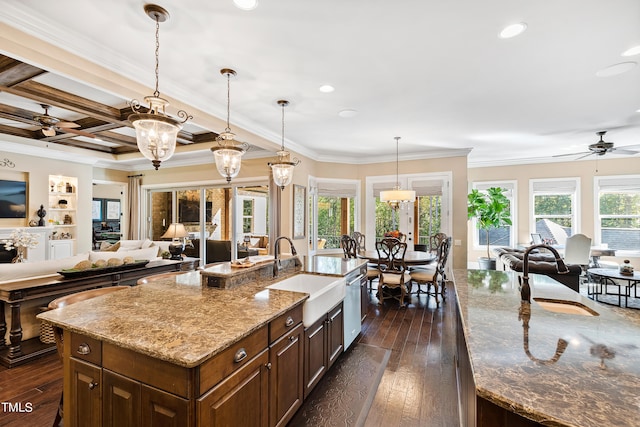 kitchen with a center island with sink, light stone countertops, coffered ceiling, and dark hardwood / wood-style floors