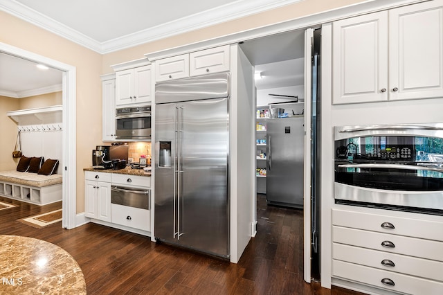 kitchen with appliances with stainless steel finishes, white cabinetry, and dark hardwood / wood-style floors