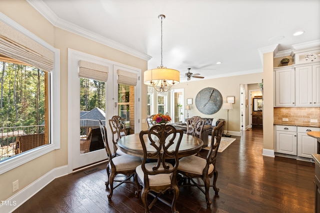 dining area featuring dark wood-type flooring, ceiling fan with notable chandelier, and ornamental molding