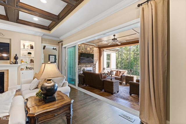 living room with ceiling fan, crown molding, coffered ceiling, a fireplace, and dark hardwood / wood-style floors