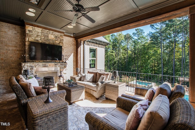 view of patio featuring ceiling fan and an outdoor living space with a fireplace