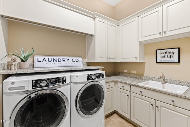 laundry area featuring cabinets, separate washer and dryer, sink, and light tile patterned floors