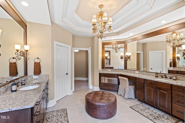 bathroom featuring vanity, a tray ceiling, a chandelier, and tile patterned flooring