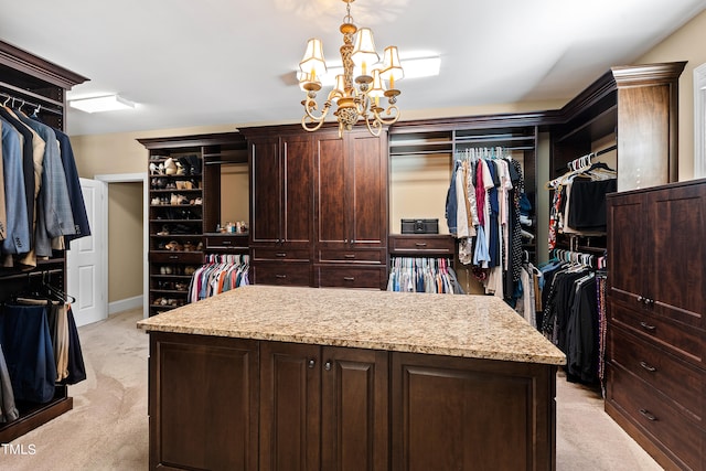 spacious closet with an inviting chandelier and light carpet