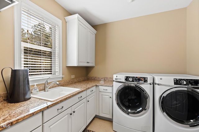 laundry room with washing machine and clothes dryer, cabinets, sink, and light tile patterned floors