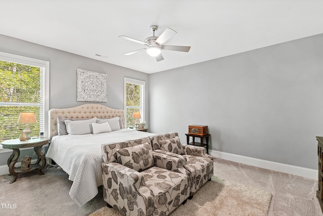 carpeted bedroom featuring multiple windows and ceiling fan