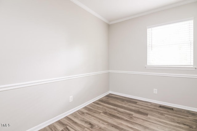 spare room featuring crown molding and hardwood / wood-style floors