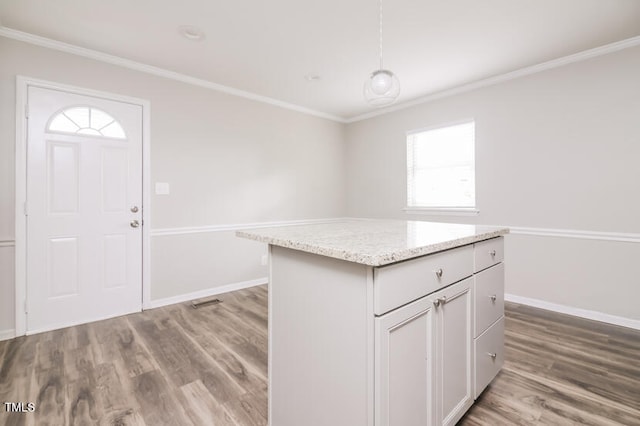 interior space featuring a healthy amount of sunlight, a center island, and light wood-type flooring