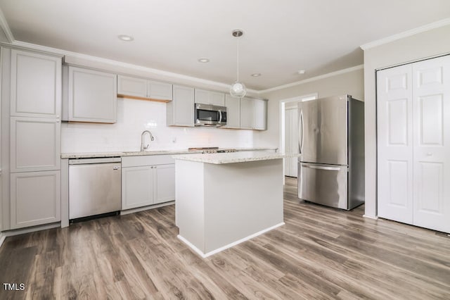 kitchen with dark wood-type flooring, stainless steel appliances, hanging light fixtures, and a kitchen island