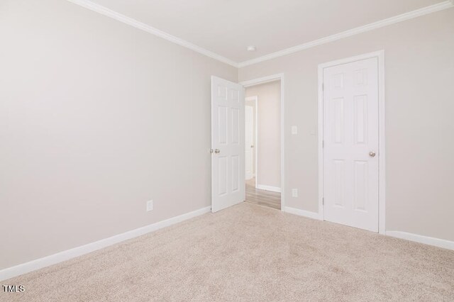 unfurnished bedroom featuring a closet, light carpet, and ornamental molding