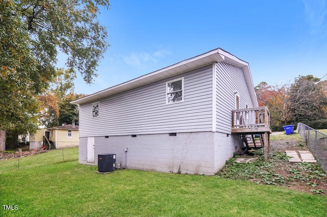 view of home's exterior featuring a deck, cooling unit, and a lawn