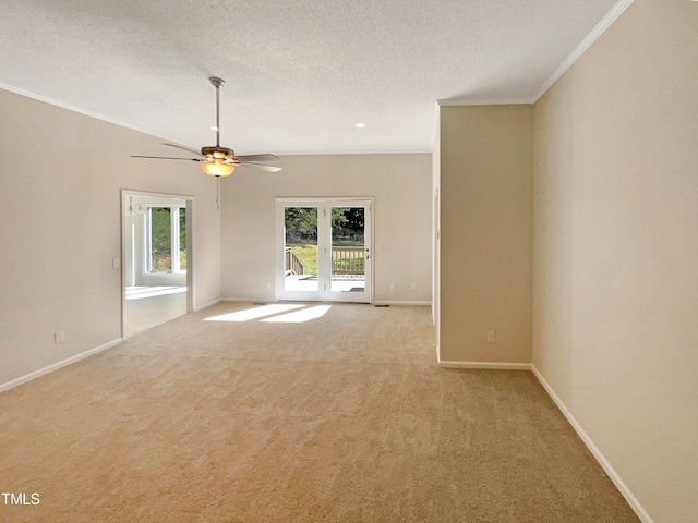 empty room with a textured ceiling, crown molding, ceiling fan, and light colored carpet