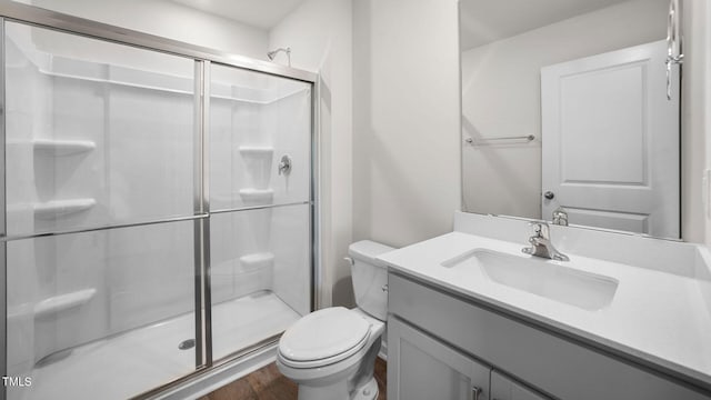 bathroom featuring an enclosed shower, wood-type flooring, vanity, and toilet