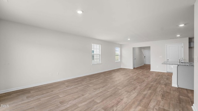 spare room with light hardwood / wood-style floors and sink