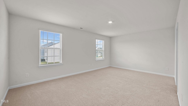 spare room featuring light colored carpet and a healthy amount of sunlight