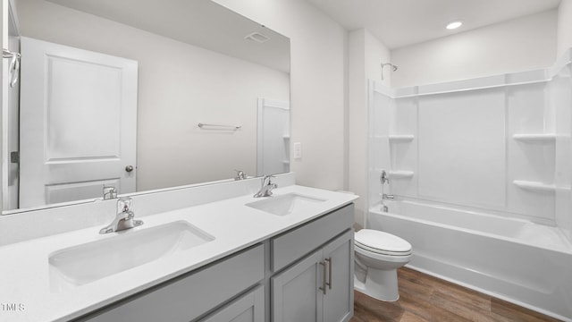 full bathroom with tub / shower combination, vanity, hardwood / wood-style floors, and toilet