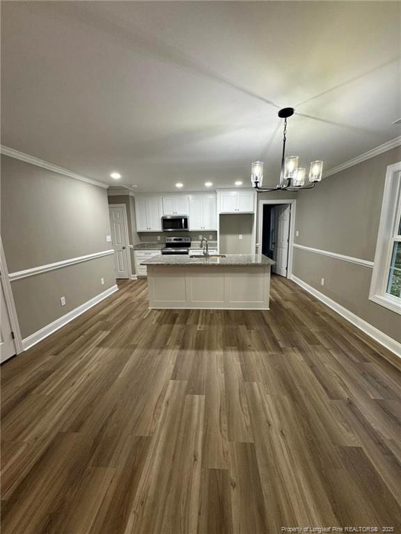 kitchen with sink, an island with sink, decorative light fixtures, white cabinets, and appliances with stainless steel finishes