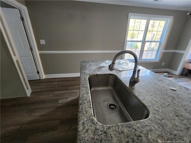 room details with light stone countertops, dark hardwood / wood-style floors, and sink