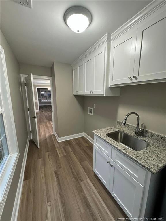 laundry room with washer hookup, dark hardwood / wood-style flooring, cabinets, and sink