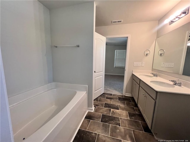 bathroom featuring tile patterned flooring, vanity, and a tub