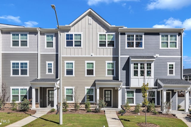 townhome / multi-family property featuring a front lawn