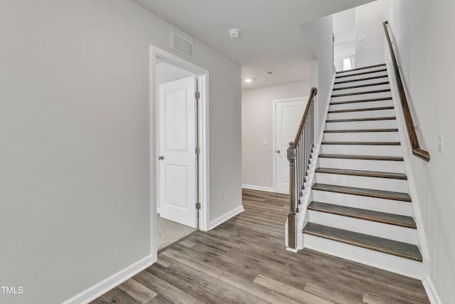 staircase with hardwood / wood-style flooring