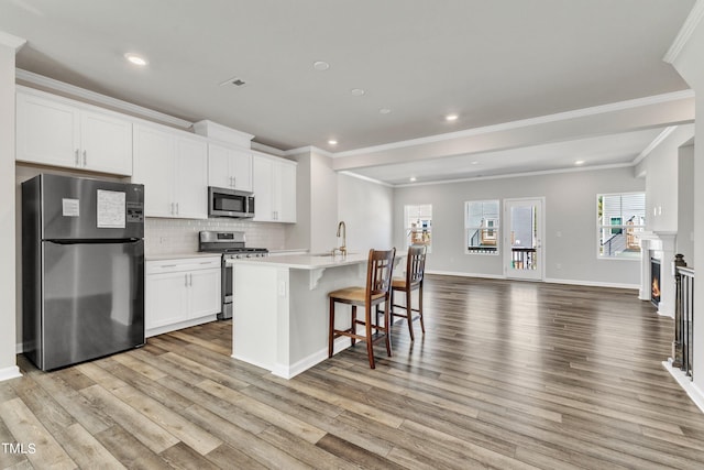 kitchen featuring appliances with stainless steel finishes, light wood-type flooring, and a healthy amount of sunlight