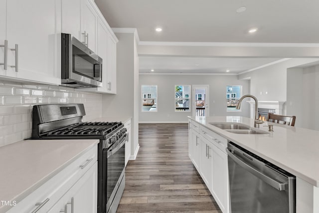 kitchen with white cabinets, backsplash, light wood-type flooring, sink, and stainless steel appliances