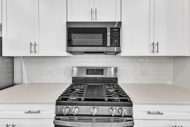 kitchen featuring appliances with stainless steel finishes, white cabinetry, and backsplash