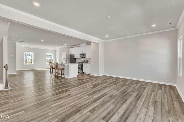 unfurnished living room with crown molding and light wood-type flooring