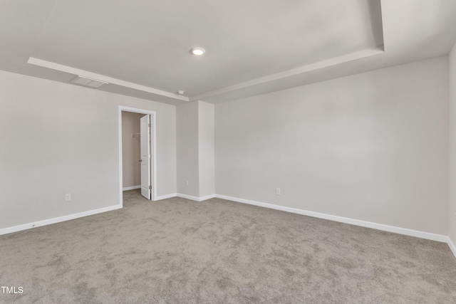 unfurnished room featuring a tray ceiling and carpet floors