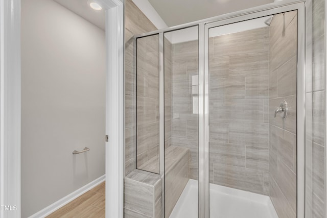 bathroom featuring a shower with shower door and hardwood / wood-style flooring