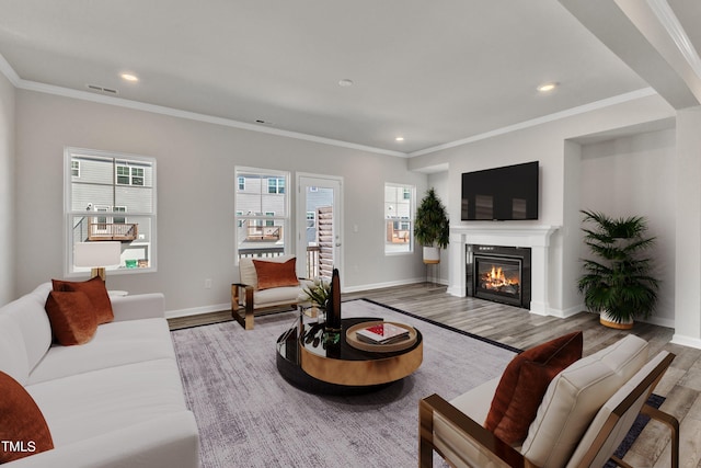 living room with light hardwood / wood-style floors, crown molding, and plenty of natural light