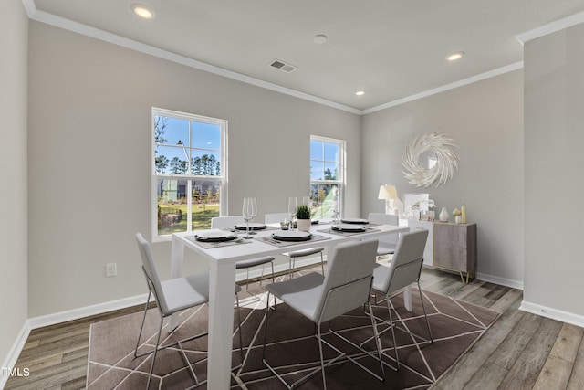 dining area featuring crown molding and hardwood / wood-style flooring