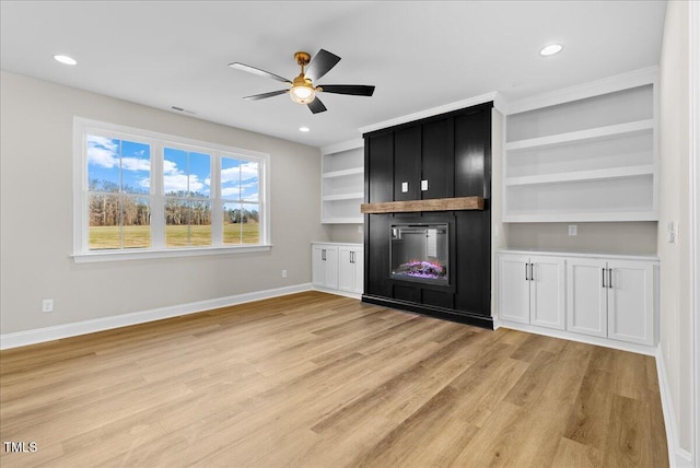 bar featuring white cabinets, ceiling fan, light hardwood / wood-style flooring, built in features, and a fireplace