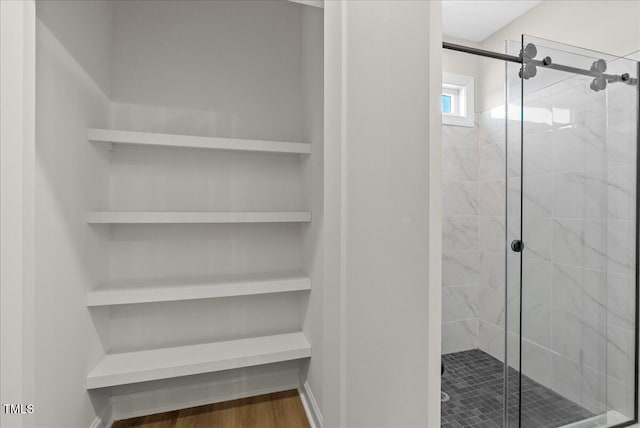 bathroom with wood-type flooring and a shower with door